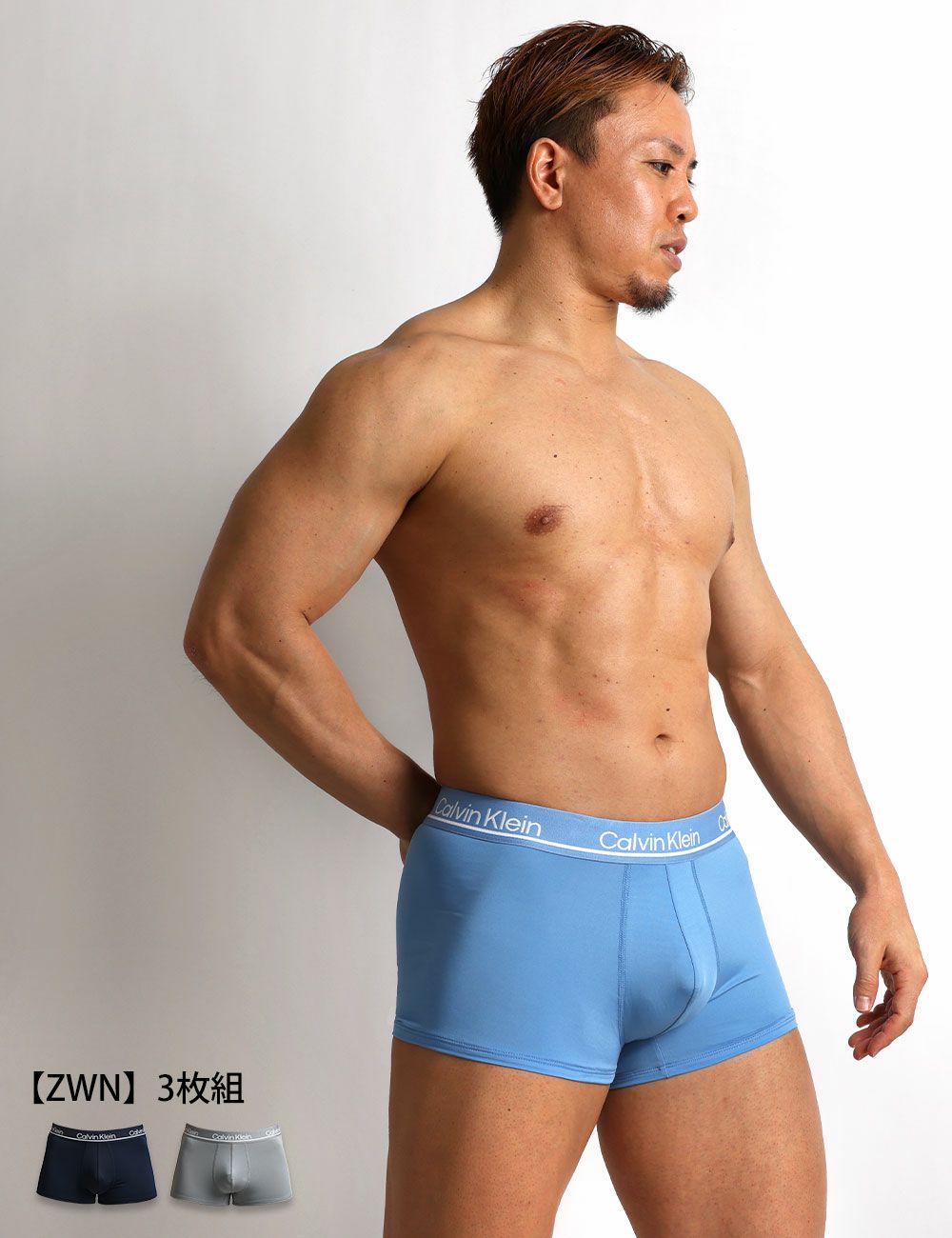 男性モデルがCalvin Kleinのスカイブルーのローライズボクサーパンツを着用。 明るい色合いと通気性の良いマイクロファイバー素材で、デイリーに快適な3枚セット。