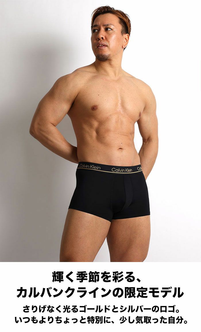 Calvin Kleinの限定モデル・ブラックのローライズボクサーパンツを着用した男性モデル。 ゴールドロゴが映えるデザインで、吸汗速乾のマイクロファイバー素材を使用。 商品名：3枚セット カルバンクライン CK Microfiber Plus メンズ下着。